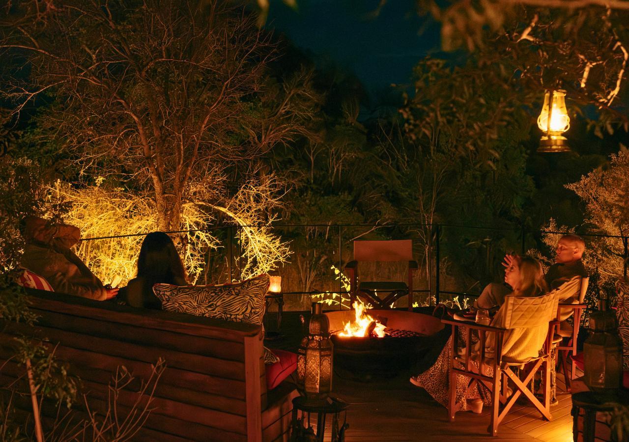 guests chatting around a campfire at a safari lodge