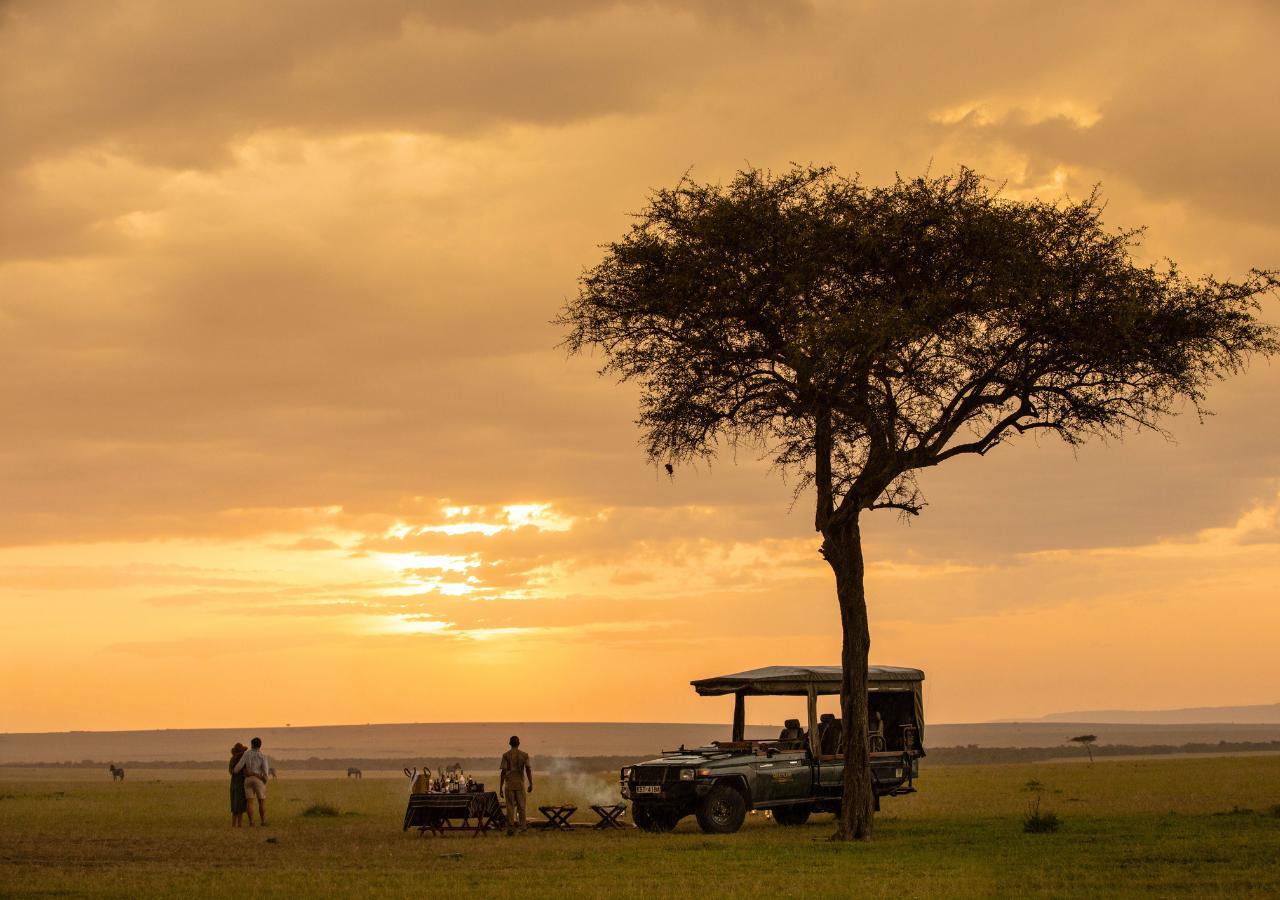 couple having a sunset meal in the bush on safari