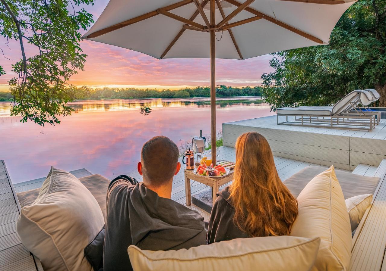 couple enjoying snacks along a river at a safari camp in Zambia