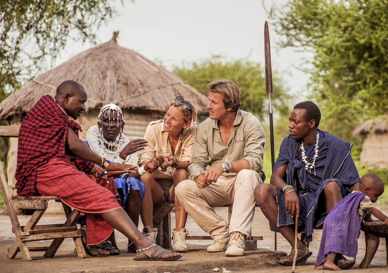 tourists sitting and talking to local community members from the Maasai