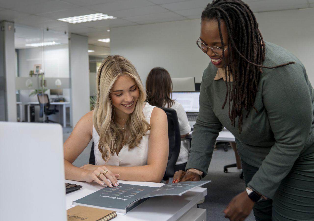 two employees chatting together at a desk at Mahlatini Luxury Travel