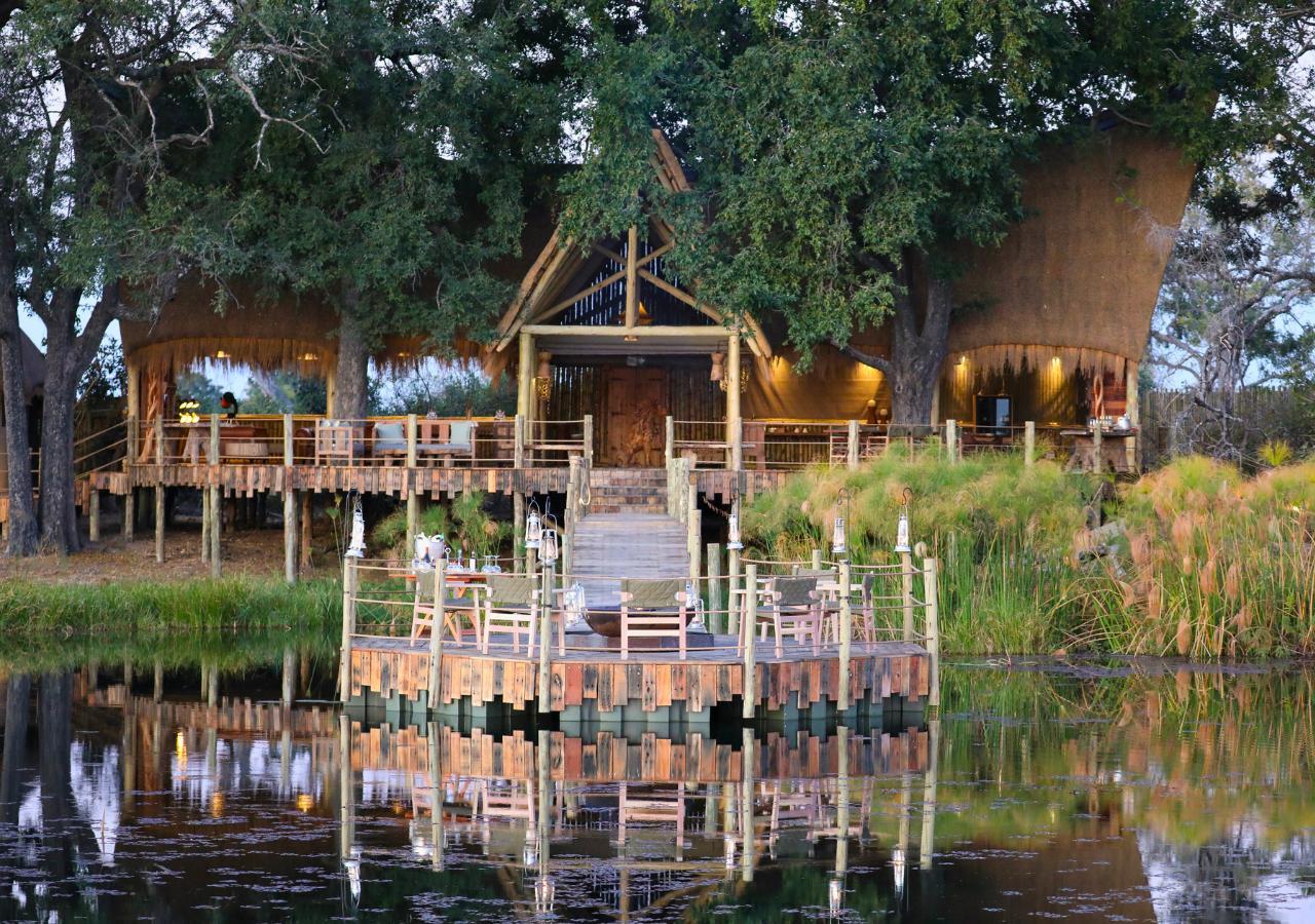 Firepit and charis on a safari lodge deck over water