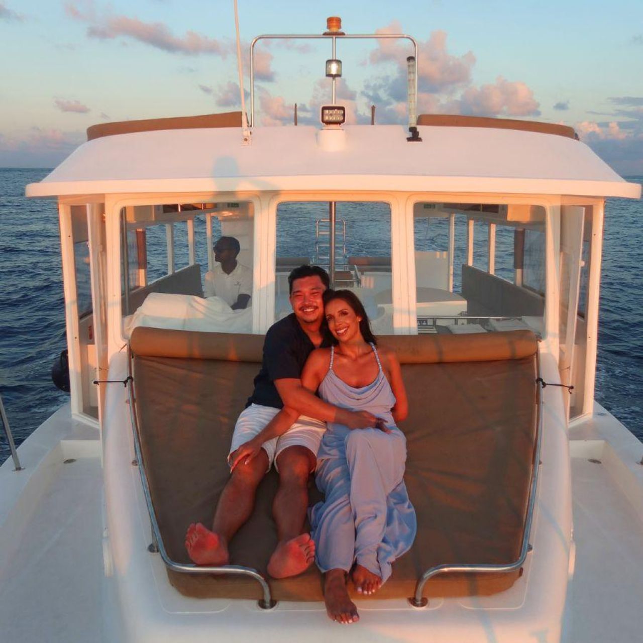 Noosha Varzandeh - Couple pose on boat in Maldives at sunset