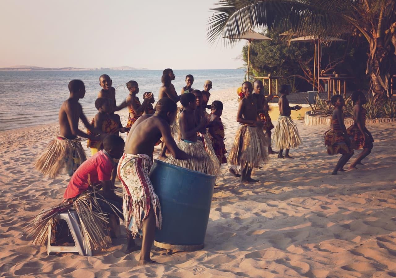 Rainbow fund children dancing on the beach at Azura Benguerra