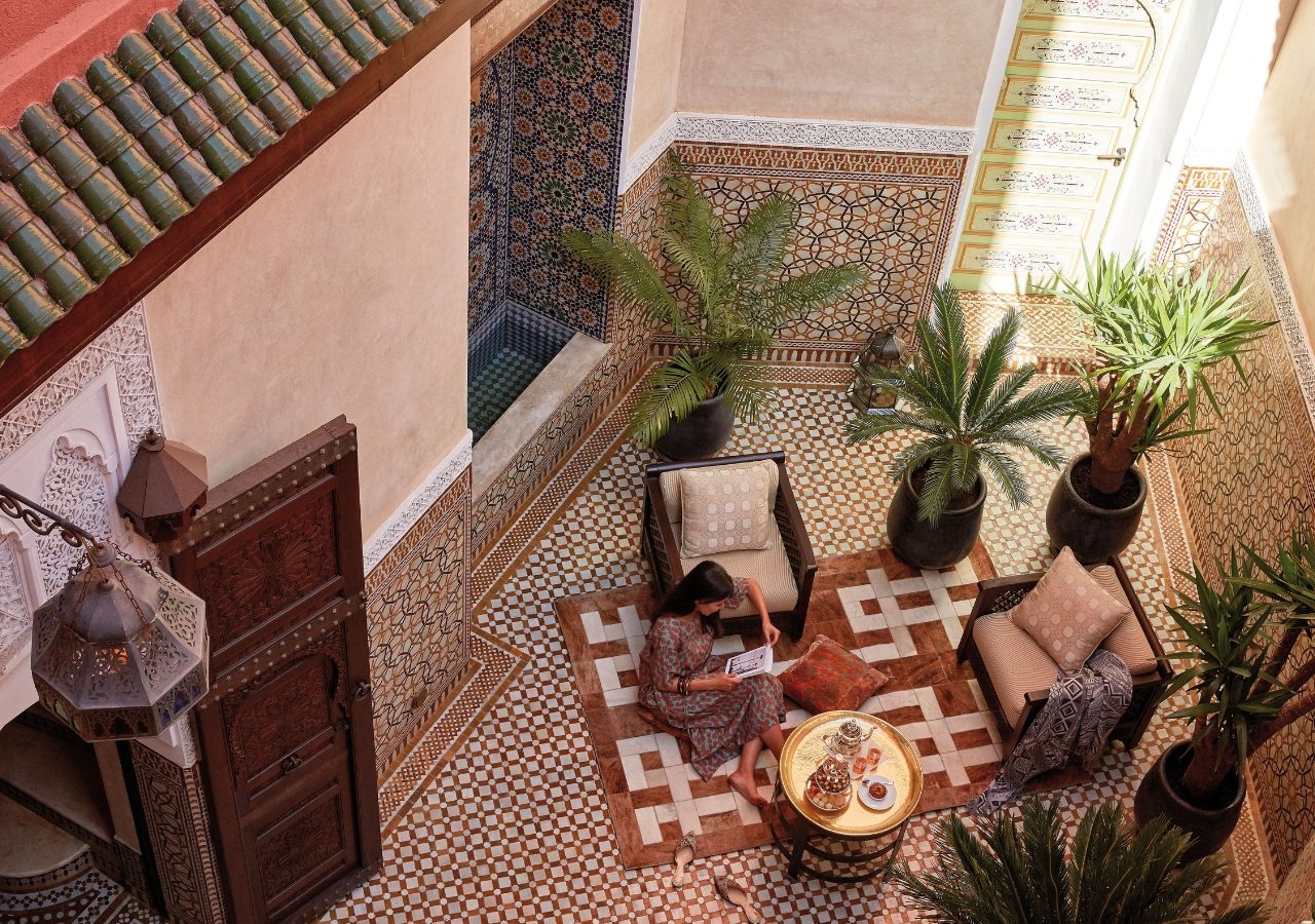 Lady reading in Riad Courtyard, Morocco