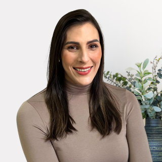 Woman posing with plants behind her