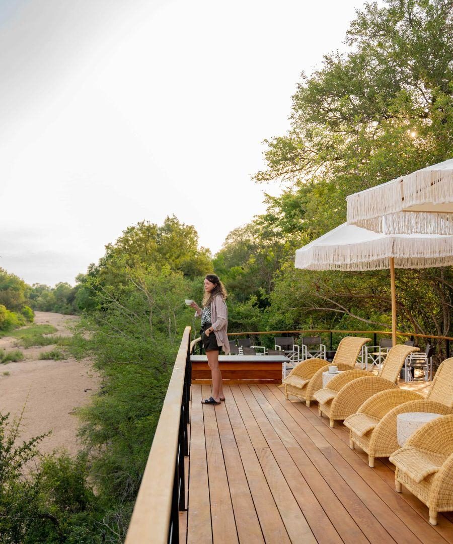 Thornybush main lodge - woman stands on balcony admiring view