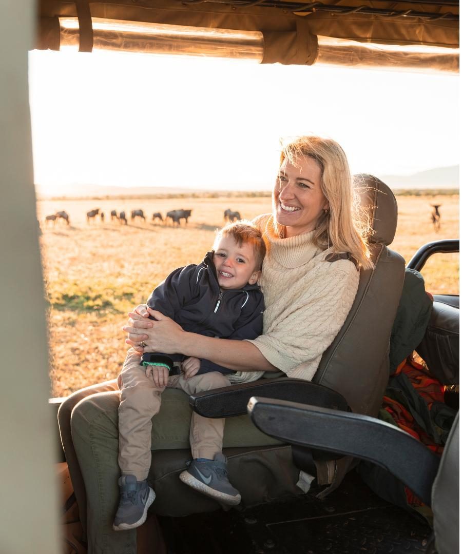 mother holding her young child on safari game drive in Kenya