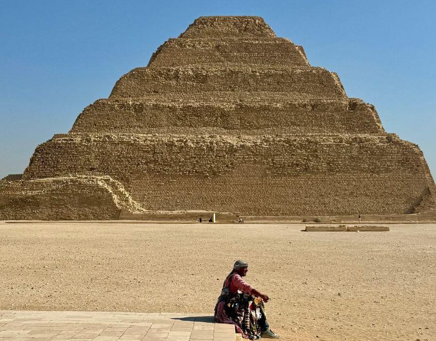 Woman takes rest in front of pyramid in Egypt