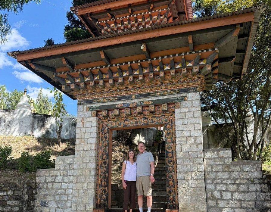 couple pose for photo in archway of temple in Bhutan