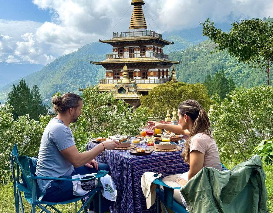 Couple enjoy tea in front of Bhutan temple