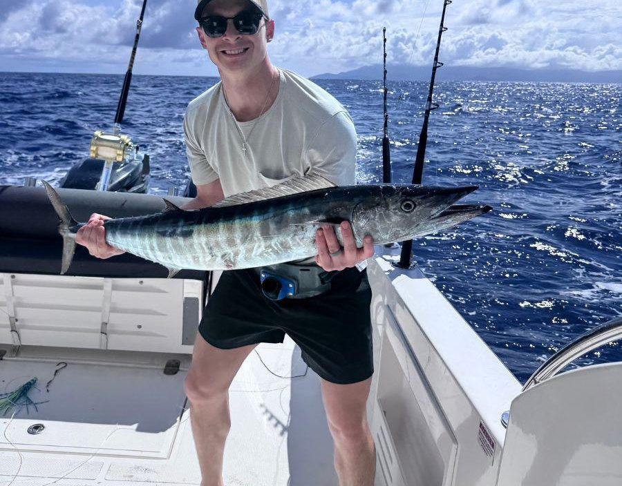 Deep sea fishing in Seychelles. Man stands on boat with his catch