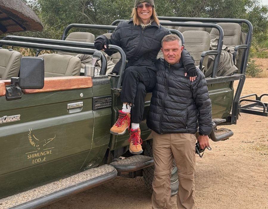 Couple pose on safari vehicle in South Africa
