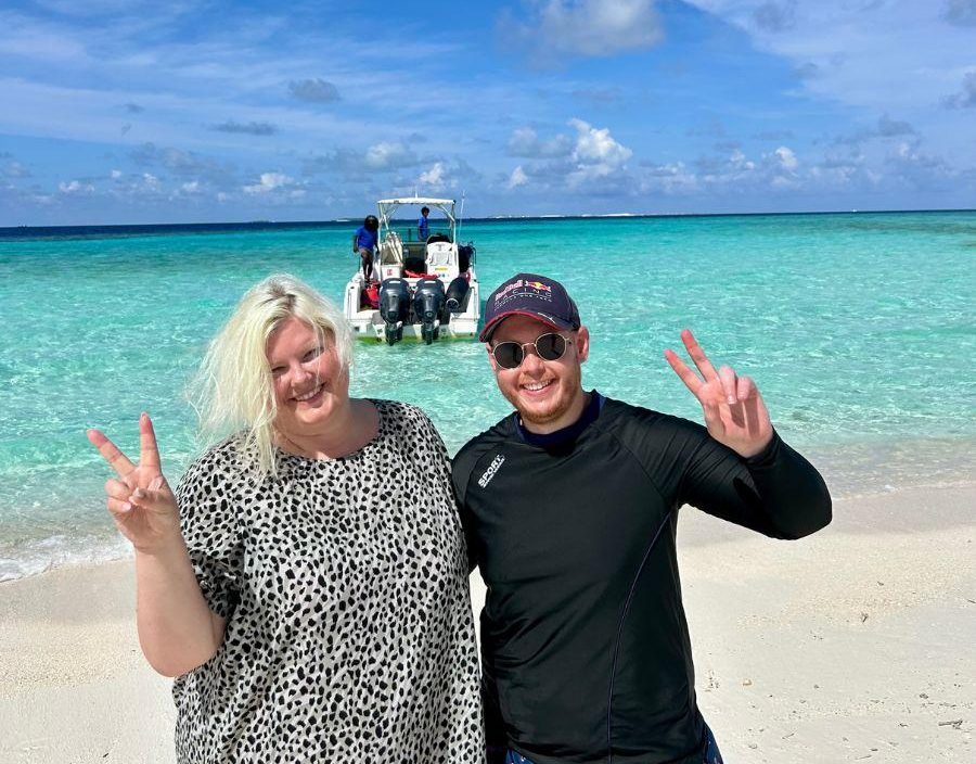 Couple pose on beach in Maldives