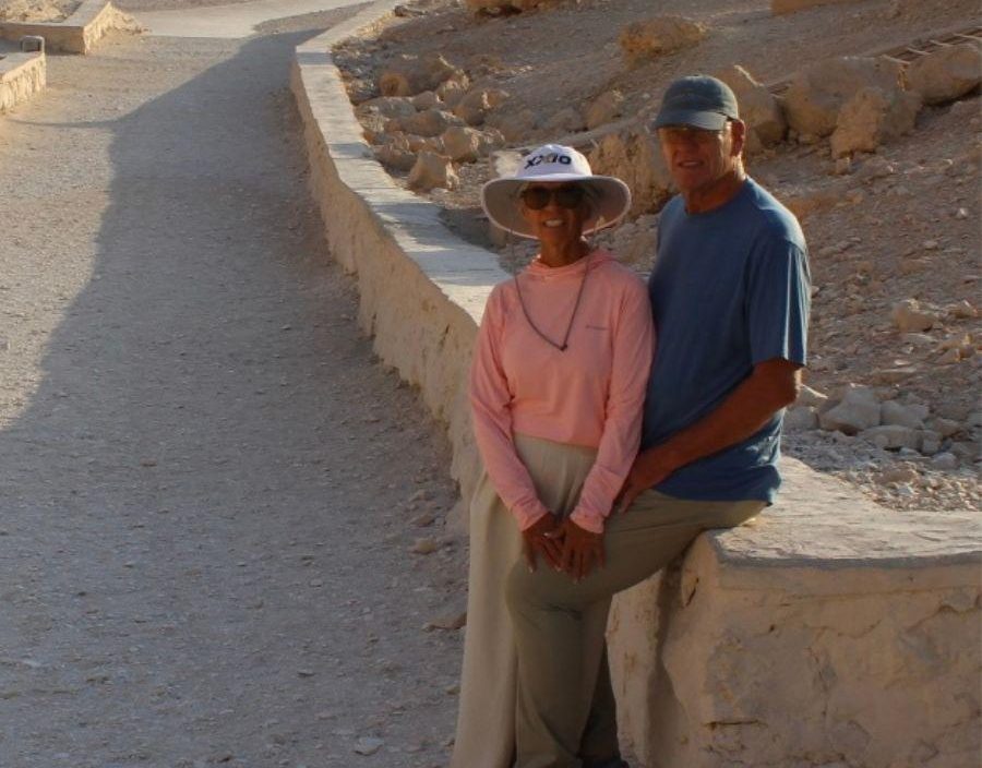 Couple pose for photo on ancient walls in Egypt
