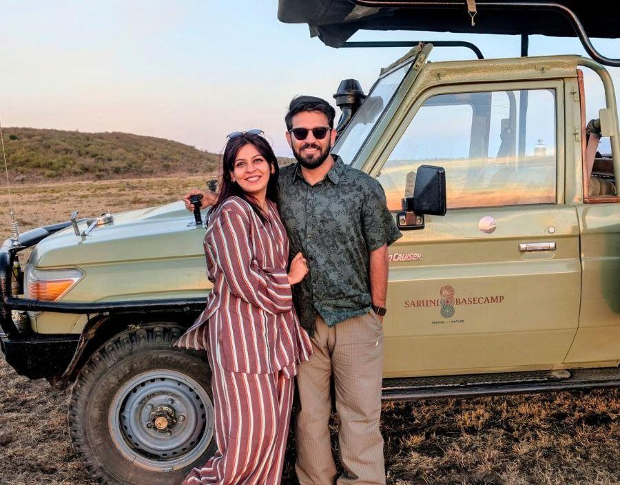 A couple standing next to a safari vehicle in Kenya.