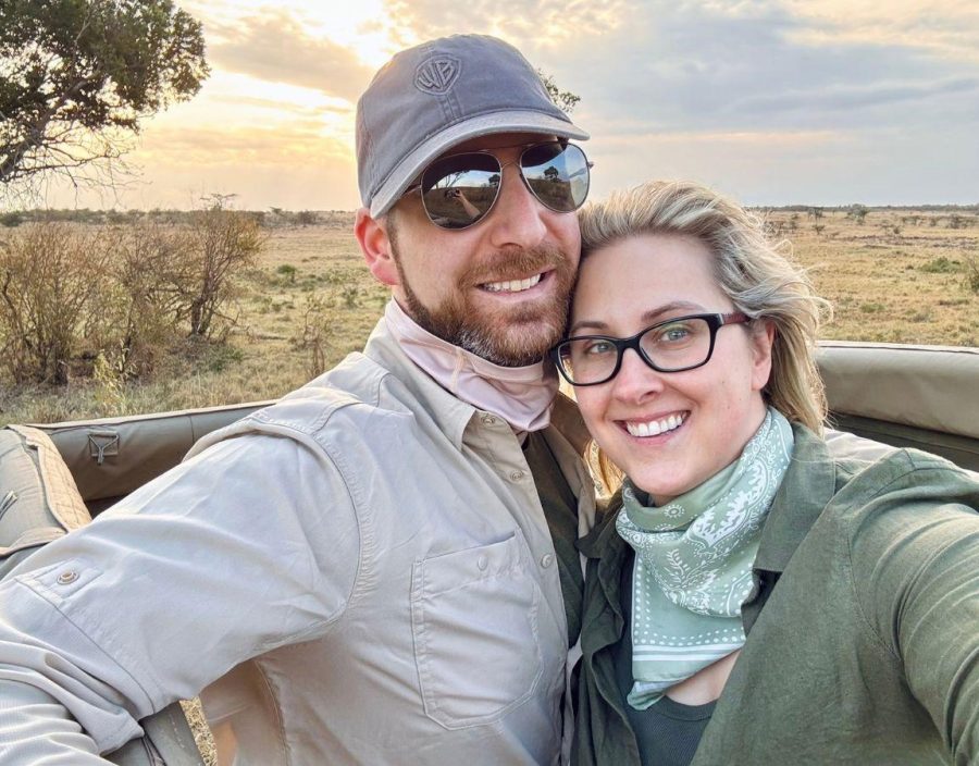 couple standing inside a safari vehicle with no roof in Kenya at sunset