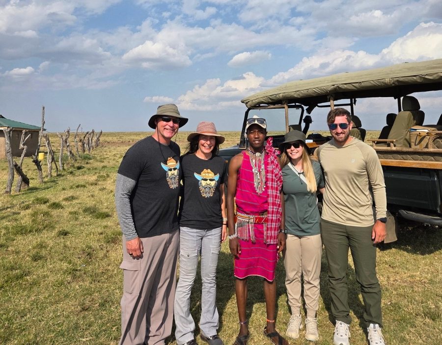 family pose on safari with maasai guide