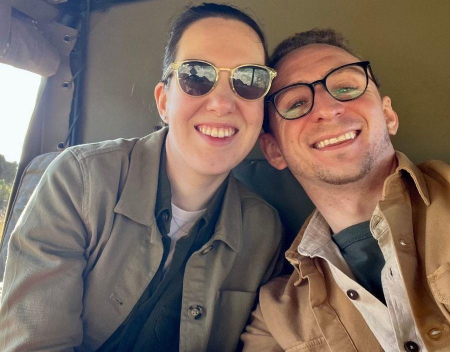 Couple pose on safari vehicle in Tanzania