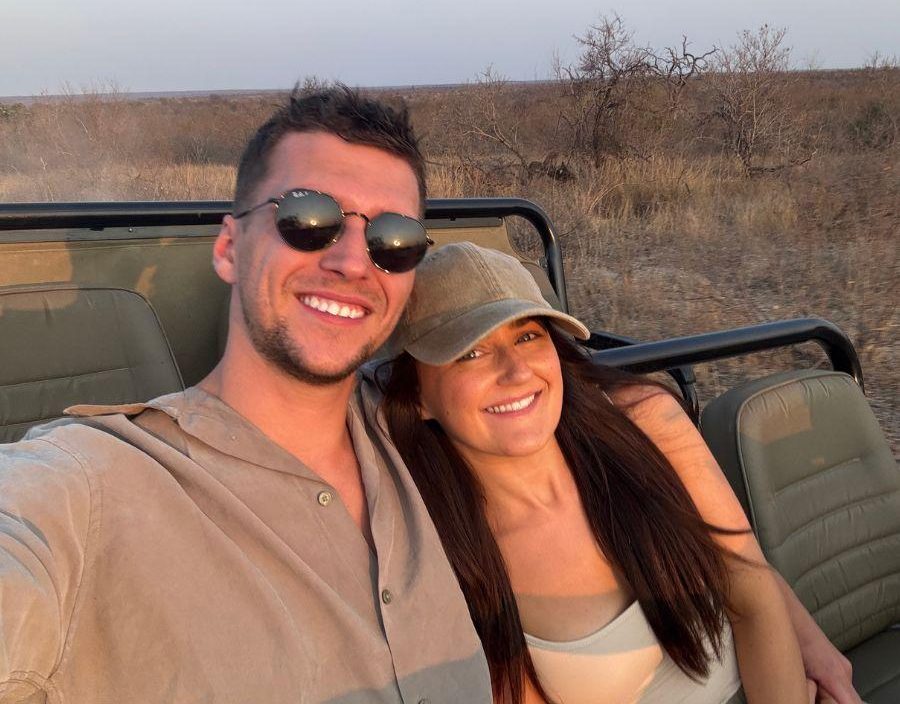 Couple pose on safari vehicle in South Africa