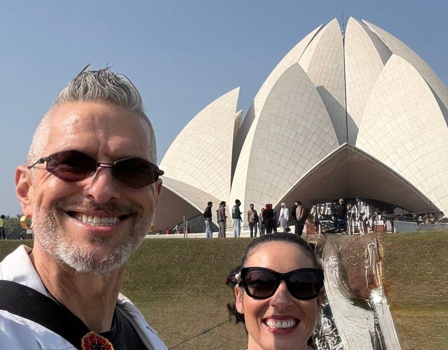 couple pose in front of lotus temple in new delhi
