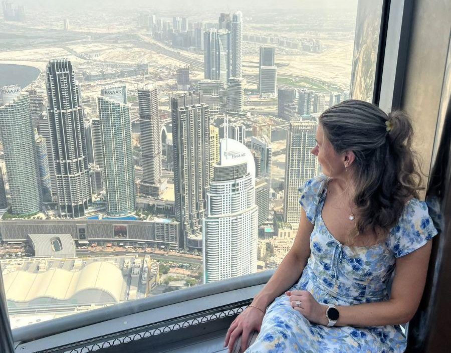 Woman looks out window of Burj Khalifa in Dubai