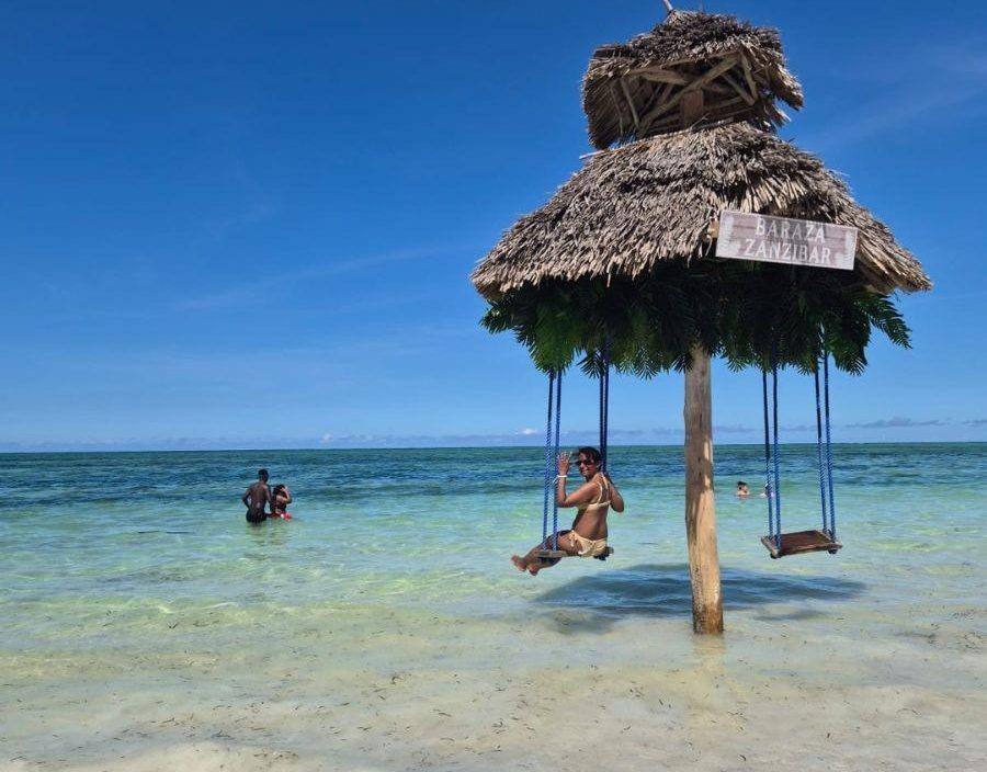 Woman poses on over sea swing in Zanzibar