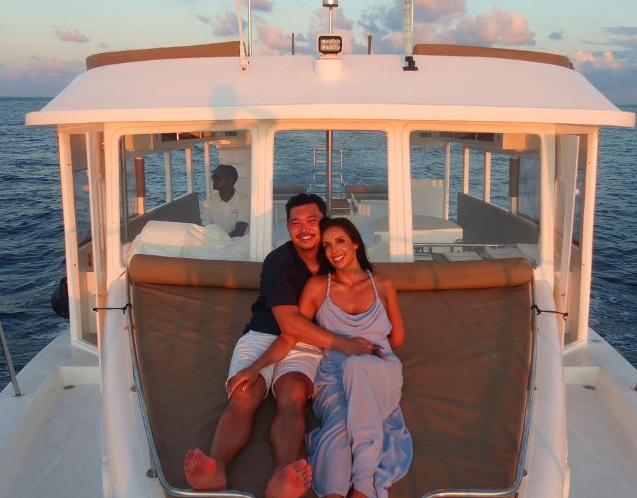 Couple pose on boat in Maldives at sunset