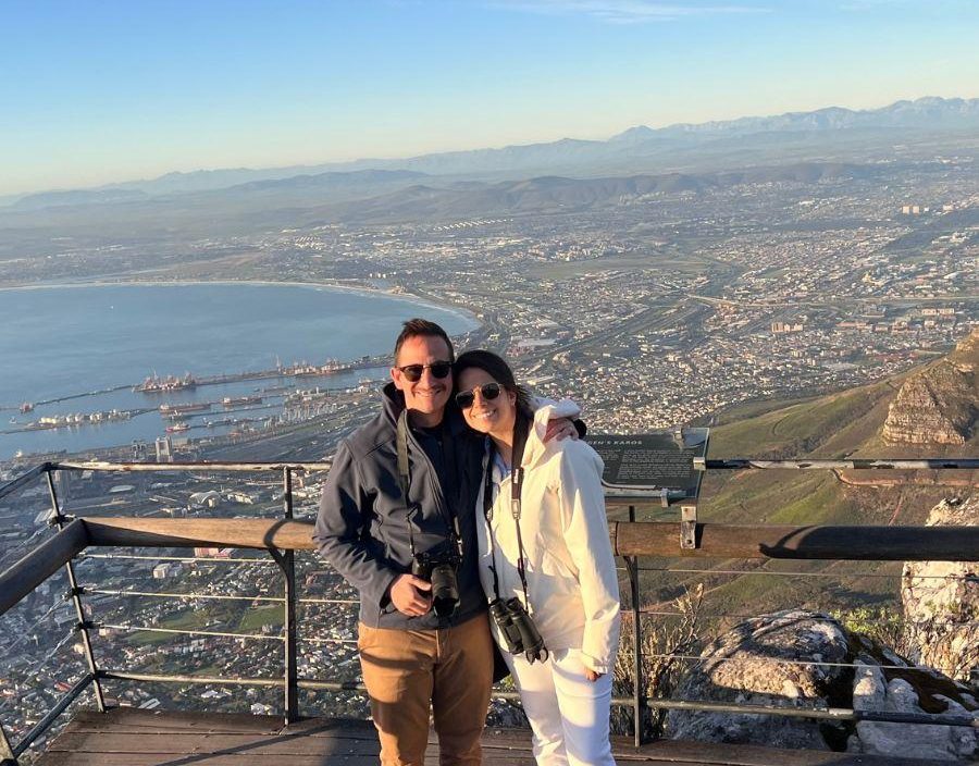 Couple post for photo on top of Table Mountain in Cape Town