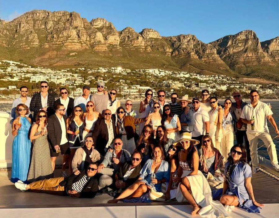 group of people pose in front of 12 apostle mountains in south africa