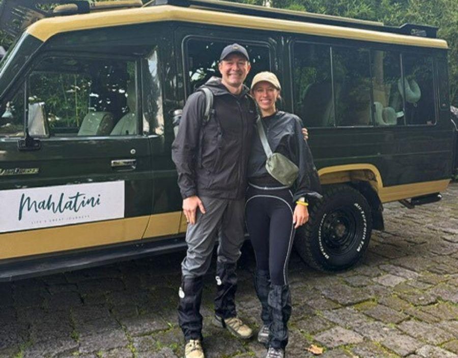 Couple pose in front of Mahlatini safari vehicle