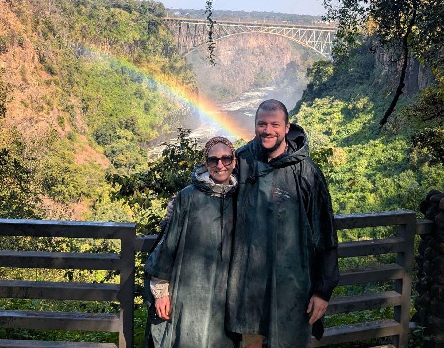 Couple pose in front of rainbow at victoria falls zimbabwe