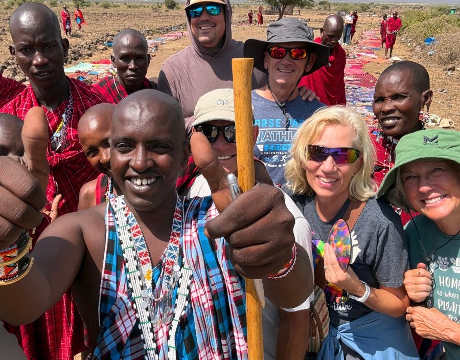 group pose for photo with men in traditional dress in rwanda