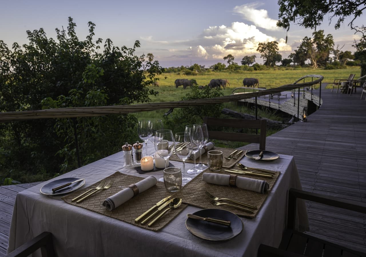 Little mombo camp dinner setting with elephants passing 1280