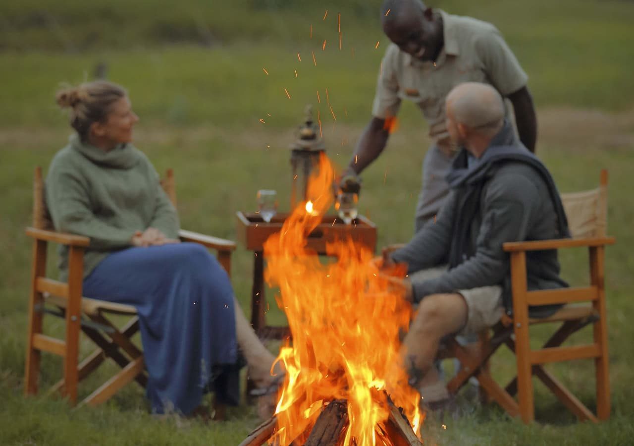 Asilia ol pejeta bush camp guests enjoying drinks around the campfire 1280