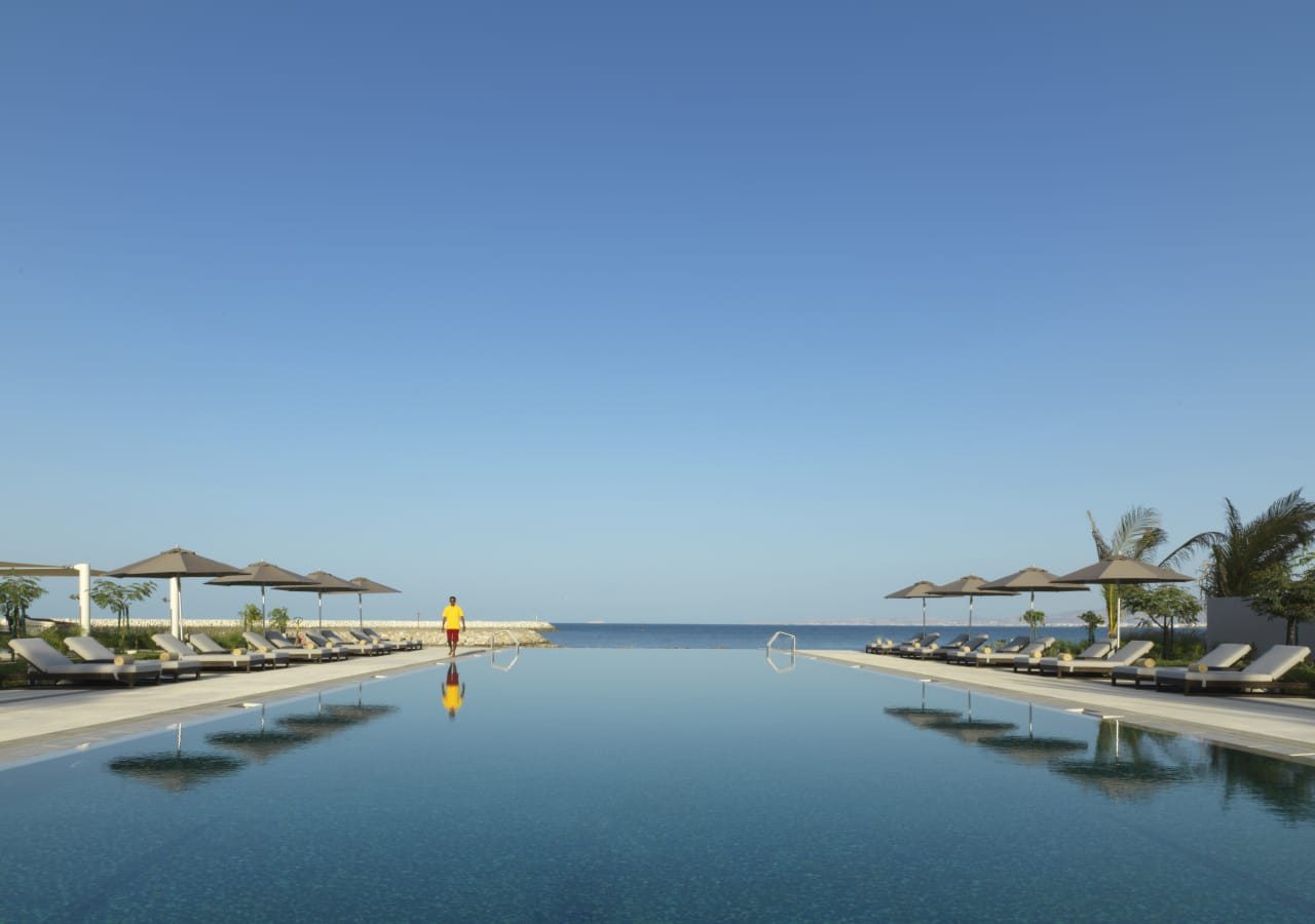 Kempinski hotel muscat infinity pool overlooking the beach 1280