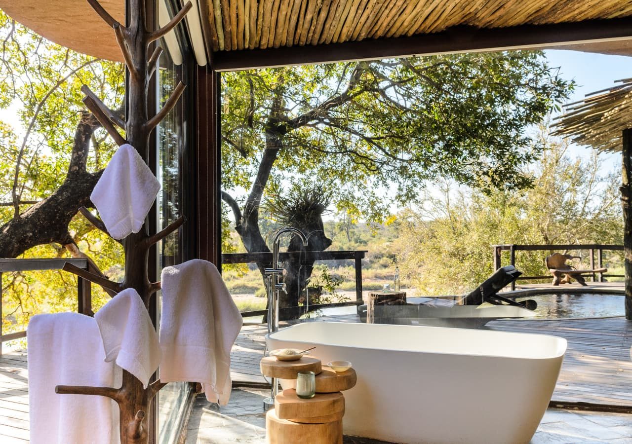 Singita boulders lodge bathroom overlooking the pool 1280