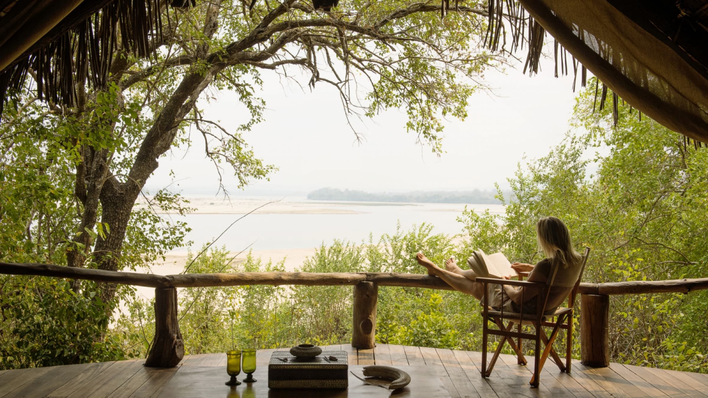 Sand rivers selous reading a book on the private deck 2400