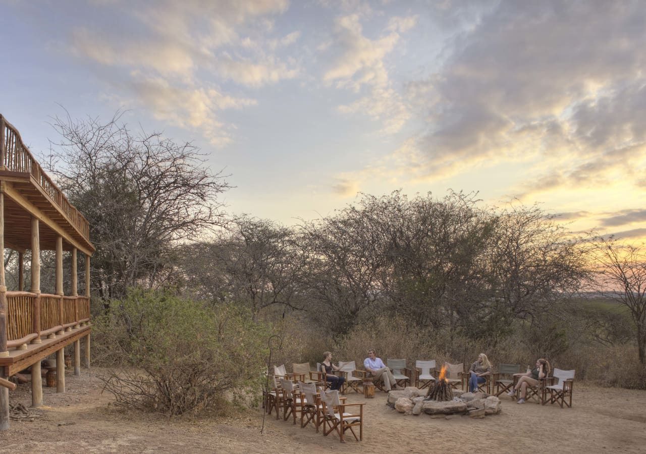 Asilia olivers camp sundowners by the fire 1280