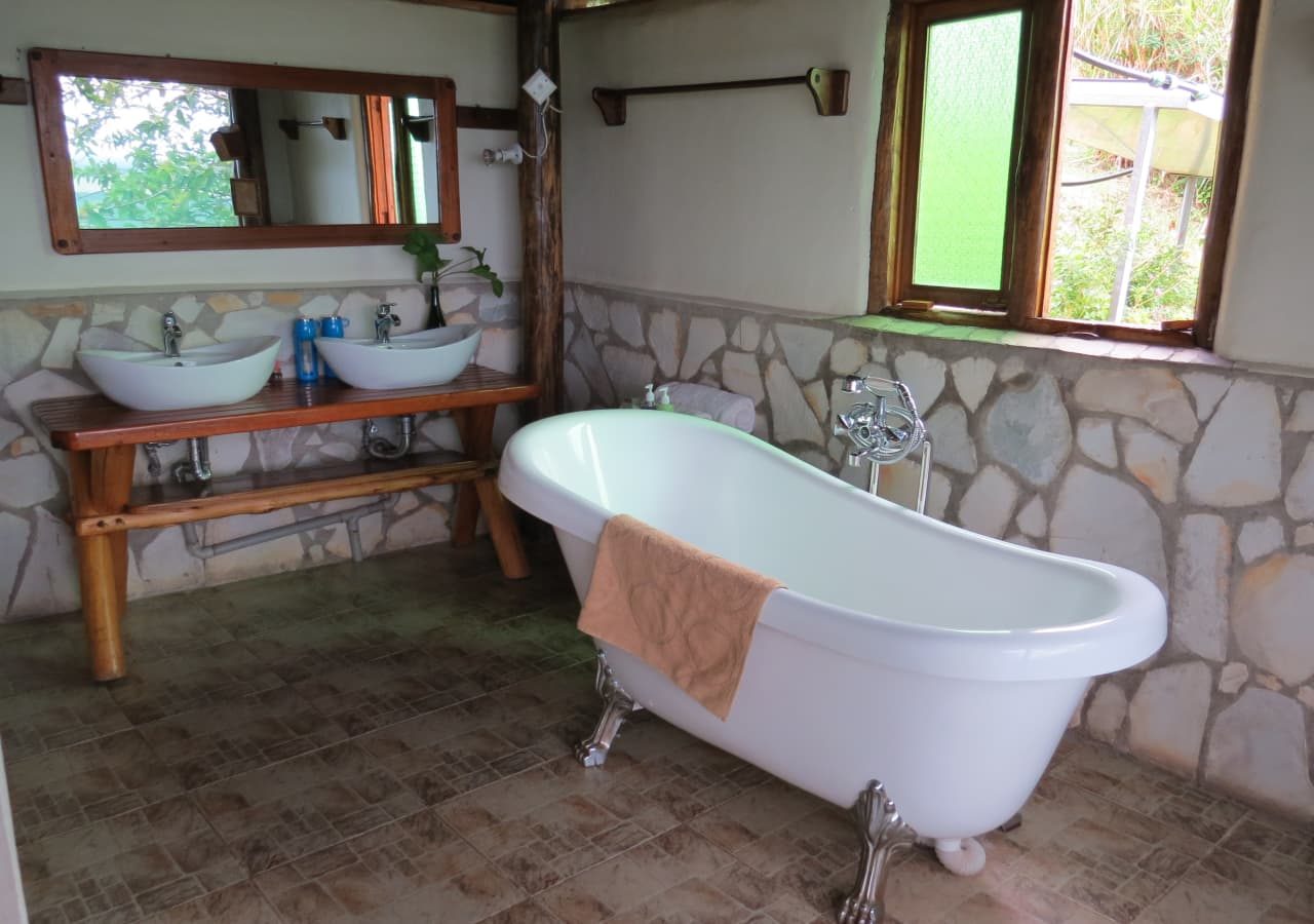 Katara lodge guest bathroom with a bathtub 1280