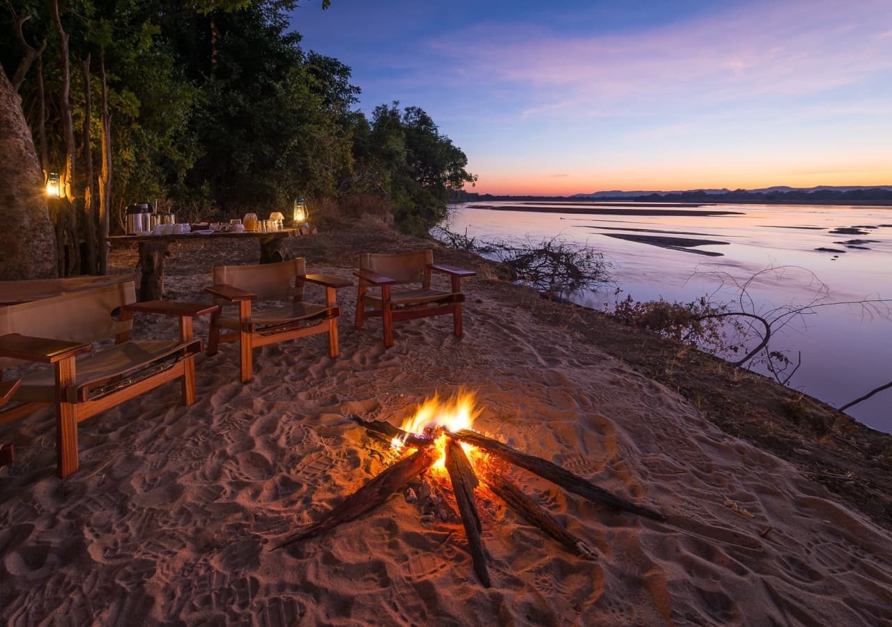 Bilimungwe bushcamp sunset bonfire by the river 1280