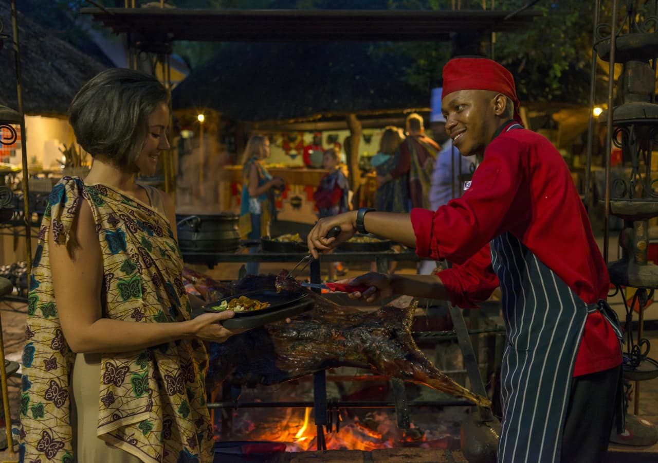 Victoria falls safari suites guest being served at the braai area 1280